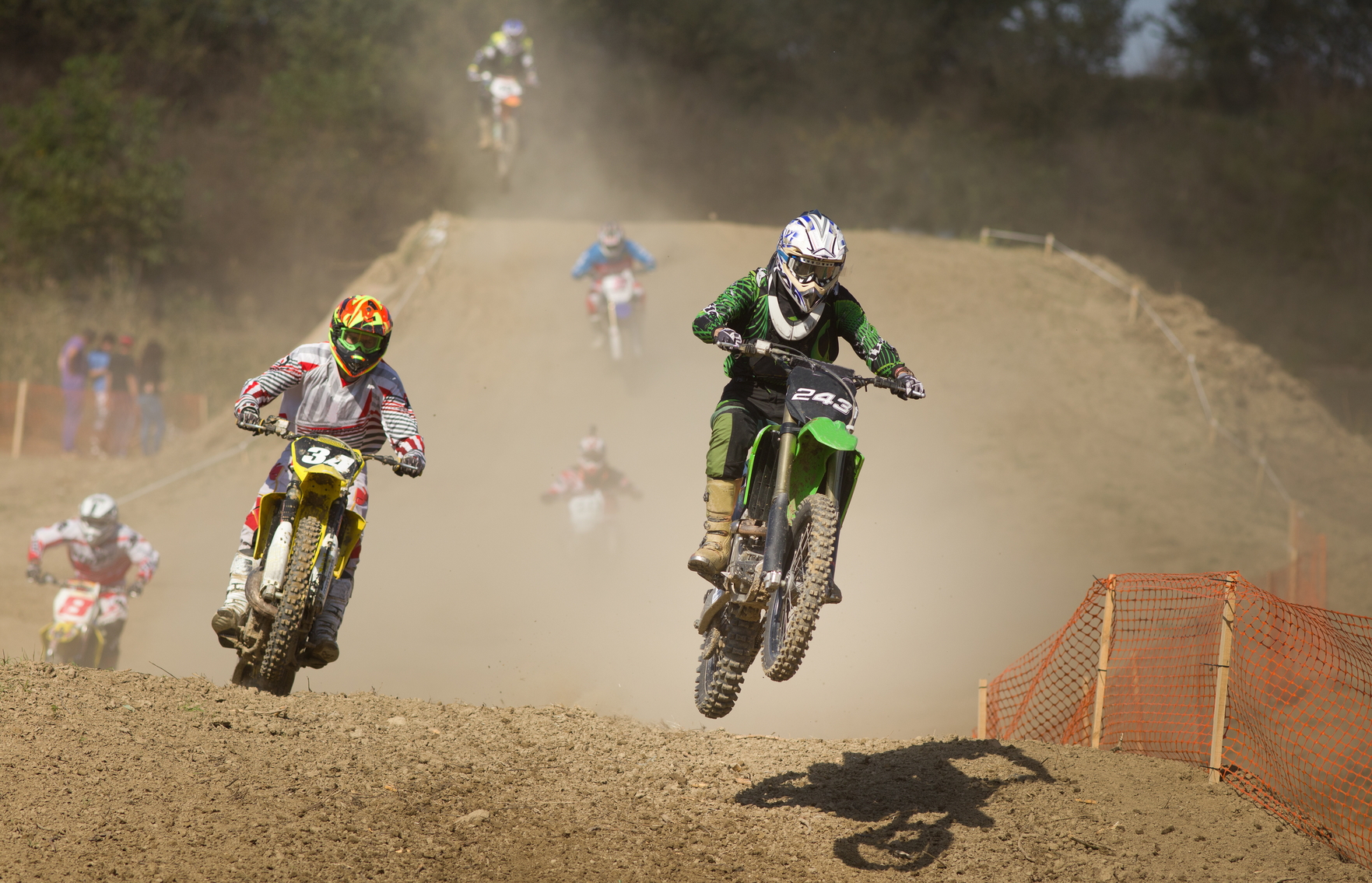 Bikers riding motorcycles in mud at off road race